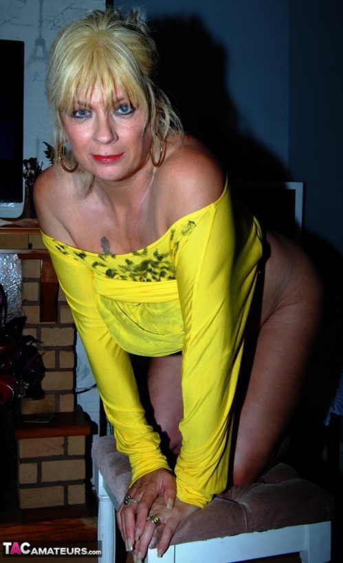Горячая зрелая мамочка в желтом позирует в обнаженном виде hd порно фото